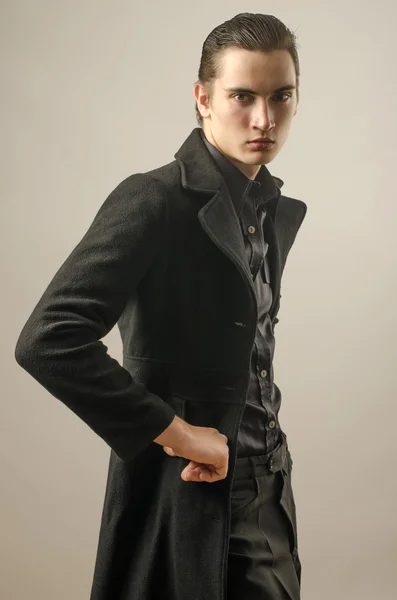 Young businessman dressed in black shirt,pants and wearing a long coat — Stock Photo, Image