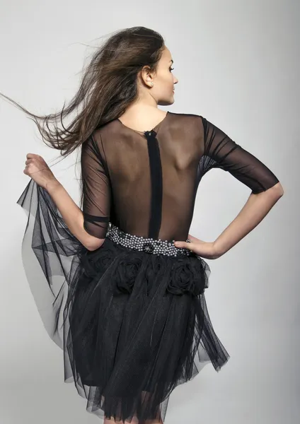 Menina posando moda das costas usando um vestido preto de renda. Jovem com ver através do vestido nas costas — Fotografia de Stock