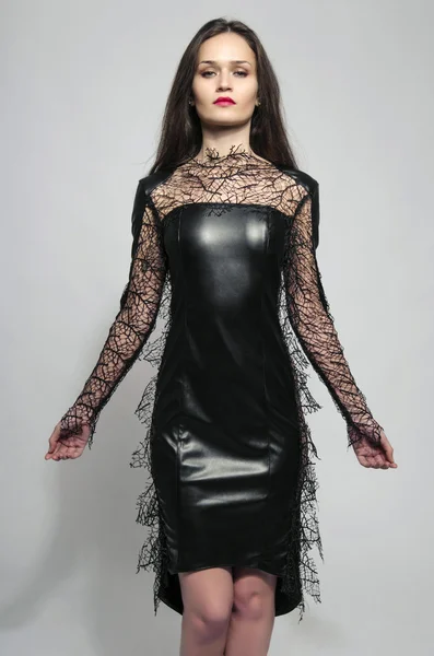 Mulher morena bonita vestindo um vestido preto e olhando o mal — Fotografia de Stock