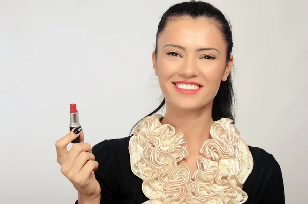 Portret van een mooie brunette vrouw rode lippenstift toe te passen op haar lippen. vrouw die met haar hand met zwarte vingernagels een rode lippenstift — Stockfoto