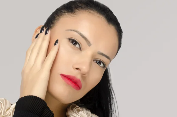 Profilo di una donna bruna con le labbra rosse che le tengono la mano sul viso e mostrano la sua nuova manicure e unghie nere, belle dita perfette — Foto Stock