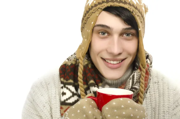 Portret piękny człowiek sobie sweter, rękawiczki, szalik i kapelusz, klejony do zimy i picia filiżankę gorącej herbaty — Zdjęcie stockowe
