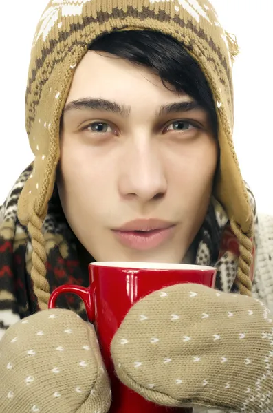 Retrato de um homem bonito vestindo suéter, luvas, cachecol e um chapéu, vestido para o inverno frio e beber uma xícara quente de chá — Fotografia de Stock