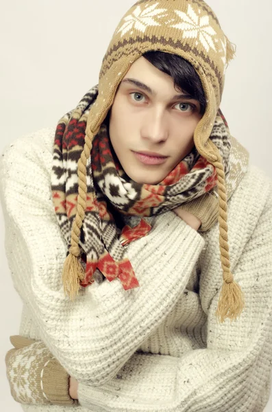 Retrato de un hombre hermoso usando suéter, guantes, bufanda y un sombrero, vestido para el frío del invierno, oliendo — Foto de Stock