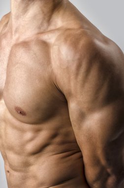 güçlü bir vücut geliştirmeci adam mükemmel abs, omuzlar, pazı, triceps ve göğüs kasların esneme ile