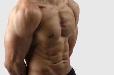 güçlü bir vücut geliştirmeci adam mükemmel abs, omuzlar, pazı, triceps ve göğüs kasların esneme ile
