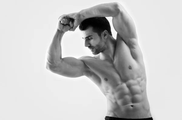 Hombre fuerte culturista con abdominales perfectos, hombros, bíceps, tríceps y pecho flexionando sus músculos —  Fotos de Stock