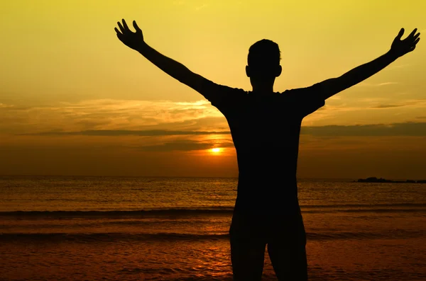 Hombre dando la bienvenida al sol, amanecer en la playa —  Fotos de Stock