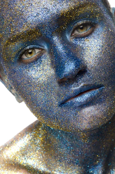 Mooi gezicht van een vrouw bedekt in glitter close up van een vrouw gezicht bedekt met blauw en paars glitter — Stockfoto