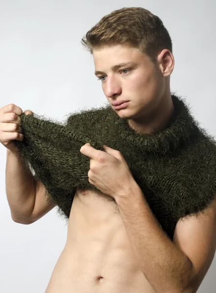 Handsome young manwearing a green blouse posing fashion in studio,showing his abs — Stock Photo, Image