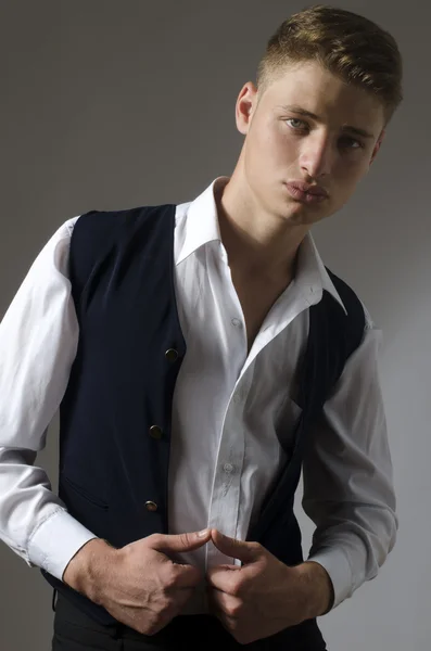 Un hombre guapo con camisa y chaleco. Joven modelo posando moda en estudio — Foto de Stock