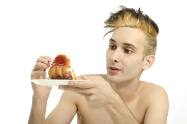 Aç genç adam yeme kremalı pasta, tatlı tatma üstsüz adam