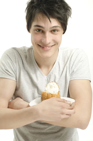 Homem feliz adorando doces. Jovem alegre segurando um bolo de creme — Fotografia de Stock