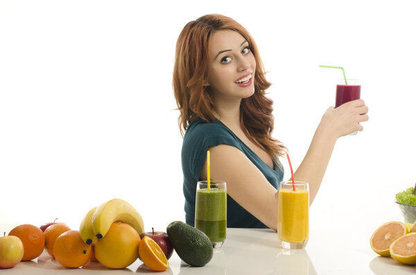 Happy woman holding an apple smoothie.. Cheerful young woman eating healthy salad, fruits , orange juice and green smoothie.