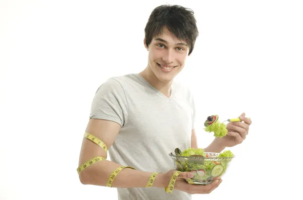 Homme mesurant son biceps avec un centimètre tout en mangeant une salade bio saine pour une alimentation parfaite. Nourriture verte pour une vie saine — Photo