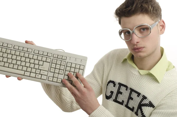 Geek playing video games with a keyboard, gamer wearing eyeglasses — Stock Photo, Image