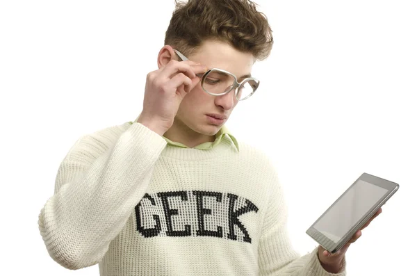 Geek dragen brillen met behulp van een tablet, gamer spelen van videogames op een draagbaar apparaat — Stockfoto