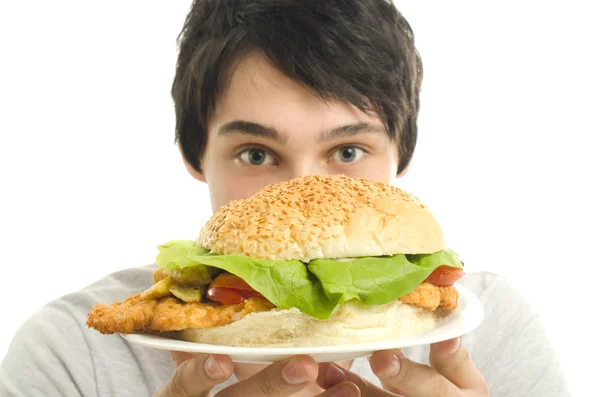 Hombre que ofrece una gran hamburguesa, comida rápida, sacar para usted —  Fotos de Stock