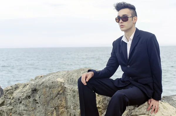 Young businessman wearing sunglasses relax on a beach and enjoy his vacation — Stock Photo, Image