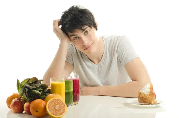 Man choosing between fruits, smoothie and organic healthy food against sweets, sugar, lots of candies, unhealthy food — Stock Photo, Image