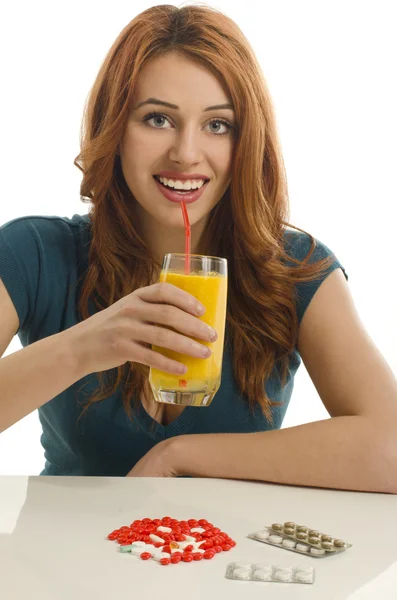 Woman choosing between pills and an organic smoothie, choosing from vitamin pills and healthy natural juice — Stock Photo, Image