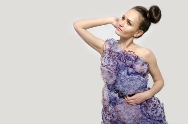 dantel çiçekler mor bir elbise giymiş ve onun kalçalarına ellerini tutan güzel bir kadın. kız moda poz. bir model profili