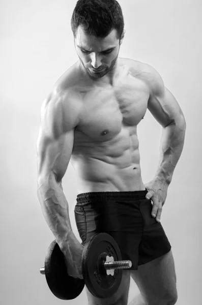 Bodybuilder met zware dumbbell training. sterke man met perfecte abs, schouders, biceps, triceps en borst. geïsoleerd op witte achtergrond — Stockfoto