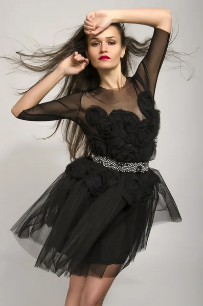 Hermosa morena vistiendo un vestido negro con flores y bailando —  Fotos de Stock