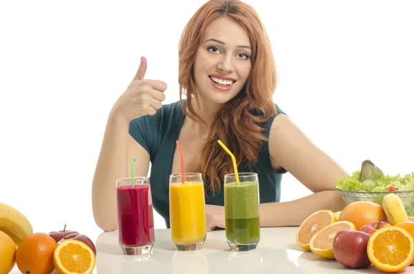 Happy woman having a table full of organic food,juices and smoothie. Cheerful young woman eating healthy salad and fruits. Isolated on white. — Stock Photo, Image