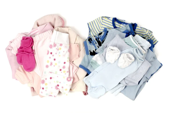 De cerca con una pila azul de ropa de bebé limpia para un niño y una ropa de bebé limpia rosa para una chica aislada en blanco — Foto de Stock
