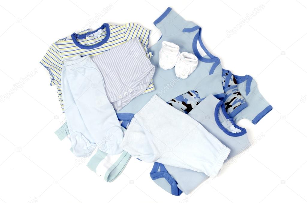 Close up with a blue stack of clean baby clothes isolated on white, pink gloves, pants,onesie,blouse,shoes