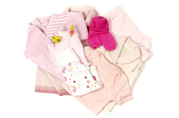 De cerca con una pila rosa de ropa de bebé limpia aislada en guantes blancos, rosados, pantalones, uno, blusa — Foto de Stock