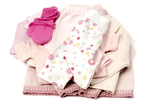 De cerca con una pila rosa de ropa de bebé limpia aislada en guantes blancos, rosados, pantalones, uno, blusa —  Fotos de Stock