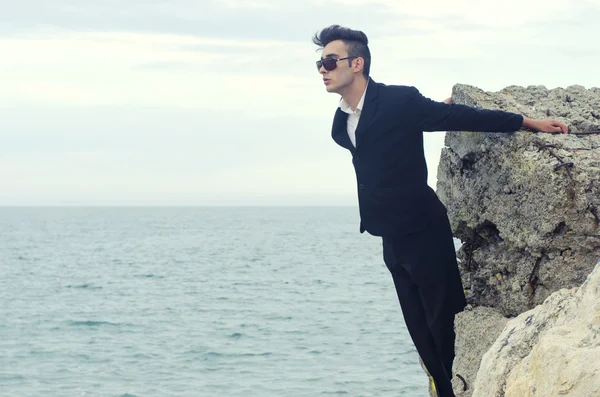 Young businessman wearing sunglasses relax on a beach and enjoy his vacation — Stock Photo, Image