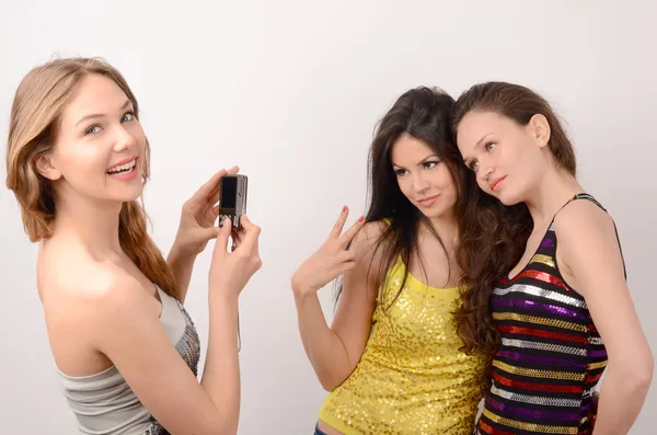 En blondin och två brunett kvinnor har kul, blond kvinna fotografering och ler ett par brunett kvinnor — Stockfoto