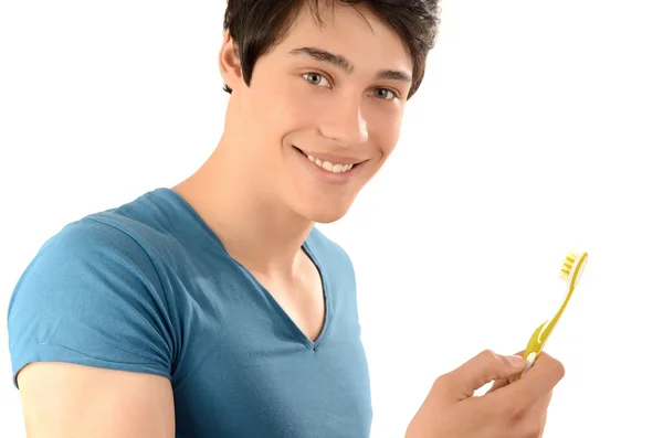 Morning routine of washing the teeth. Handsome young man with beautiful teeth smiling and holding a toothbrush. — Stock Photo, Image