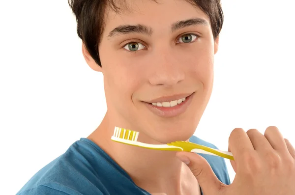 Rotina matinal de lavar os dentes. Bonito jovem com belos dentes sorrindo e segurando uma escova de dentes . — Fotografia de Stock