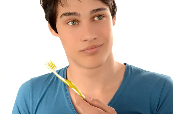 Rutina matutina de lavar los dientes. Joven guapo con hermosos dientes sonriendo y sosteniendo un cepillo de dientes . — Foto de Stock