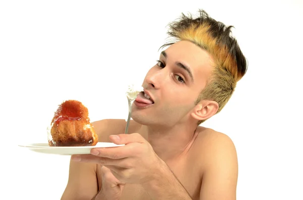 Hungry young man eating a cream cake, topless man tasting sweets — Stock Photo, Image