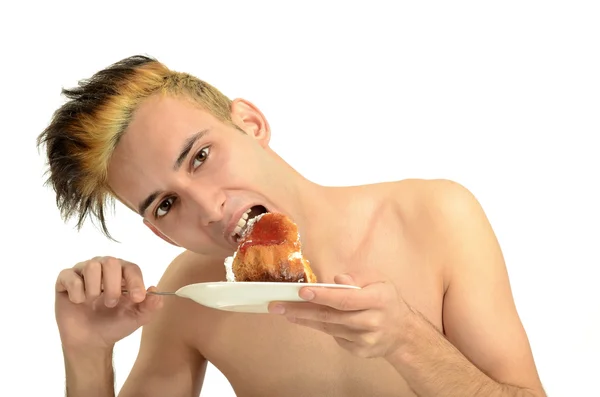 Hungry young man eating a cream cake, topless man tasting sweets — Stock Photo, Image
