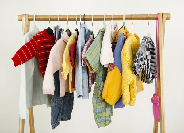 Armário de vestir com roupas dispostas em cabides. Roupeiro de recém-nascido, crianças, bebês cheios de todos os tons de azul uma roupa laranja, sapatos, acessórios e brinquedos — Fotografia de Stock