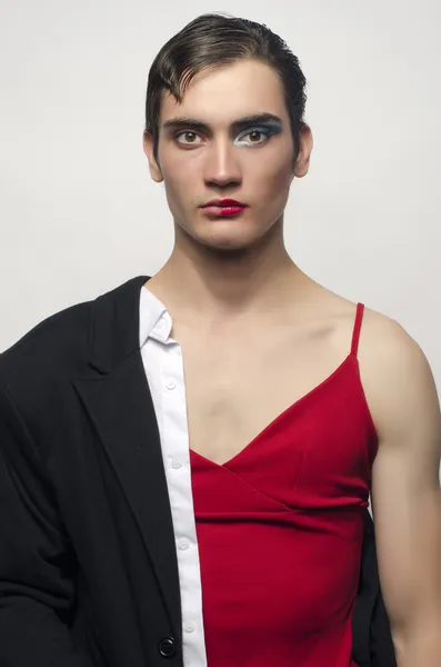 Mitad hombre, mitad mujer, usando un traje negro y un vestido rojo. Hombre enojado usando maquillaje, Retrato de una drag queen . —  Fotos de Stock