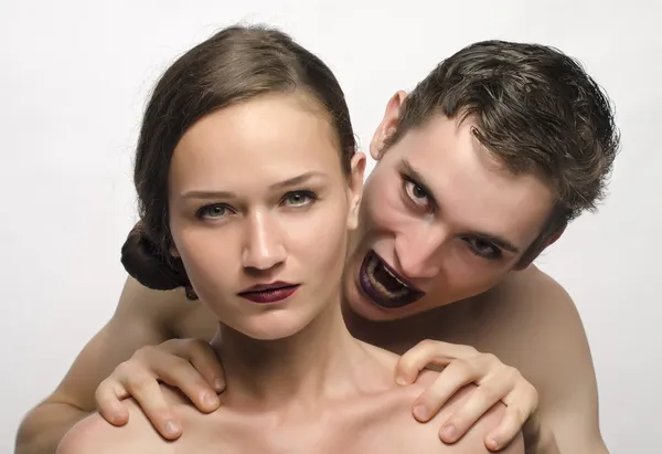 Vampiro mordiendo a una hermosa mujer, hombre malvado y una chica morena, hombre enojado usando maquillaje — Foto de Stock