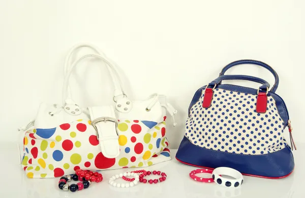 Grande borsa a pois colorata e una borsa a pois blu navy con braccialetti abbinati . — Foto Stock