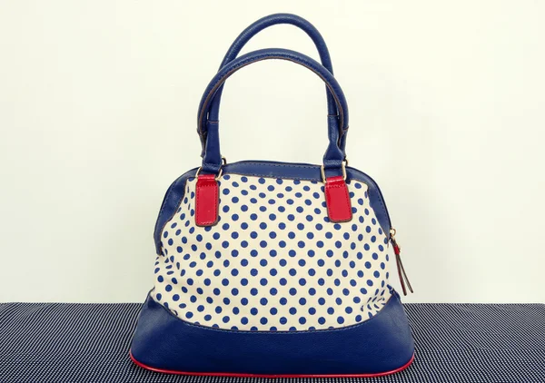 Navy blue polka dots purse on a dots surface. — Stock Photo, Image