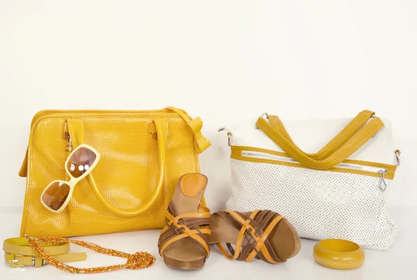 Lindos bolsos amarillos de verano con sandalias y accesorios a juego . Imagen De Stock