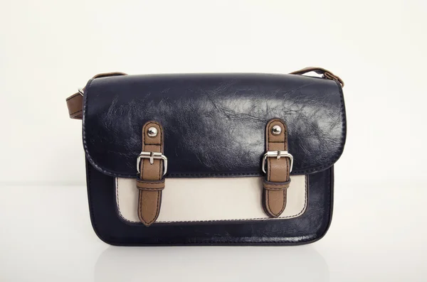 Dark blue and beige purse on white shelf. — Stock Photo, Image