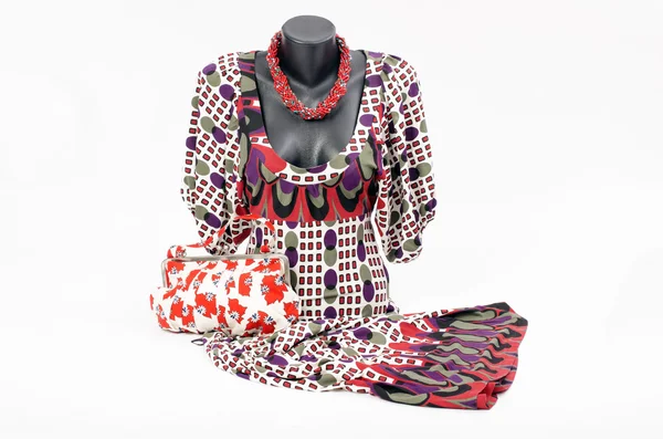 Vacker klänning på skyltdocka med matchande tillbehör. elegant klänning på tailor's dummy med matchande färgglada handväska och rött halsband — Stockfoto