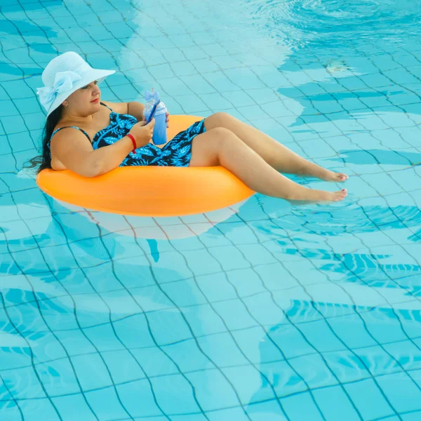 Yüzme havuzunda güneş şapkalı esmer kadın ve mayo.. — Stok fotoğraf