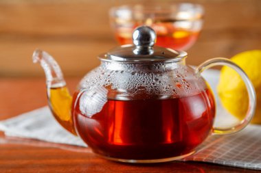 Bir çaydanlık dolusu sıcak çay peçetenin üzerinde masanın üzerinde. Yatay fotoğraf